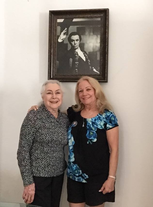 My Madrina and Terri in February 2015, standing under a photo of my Godfather, Raul.